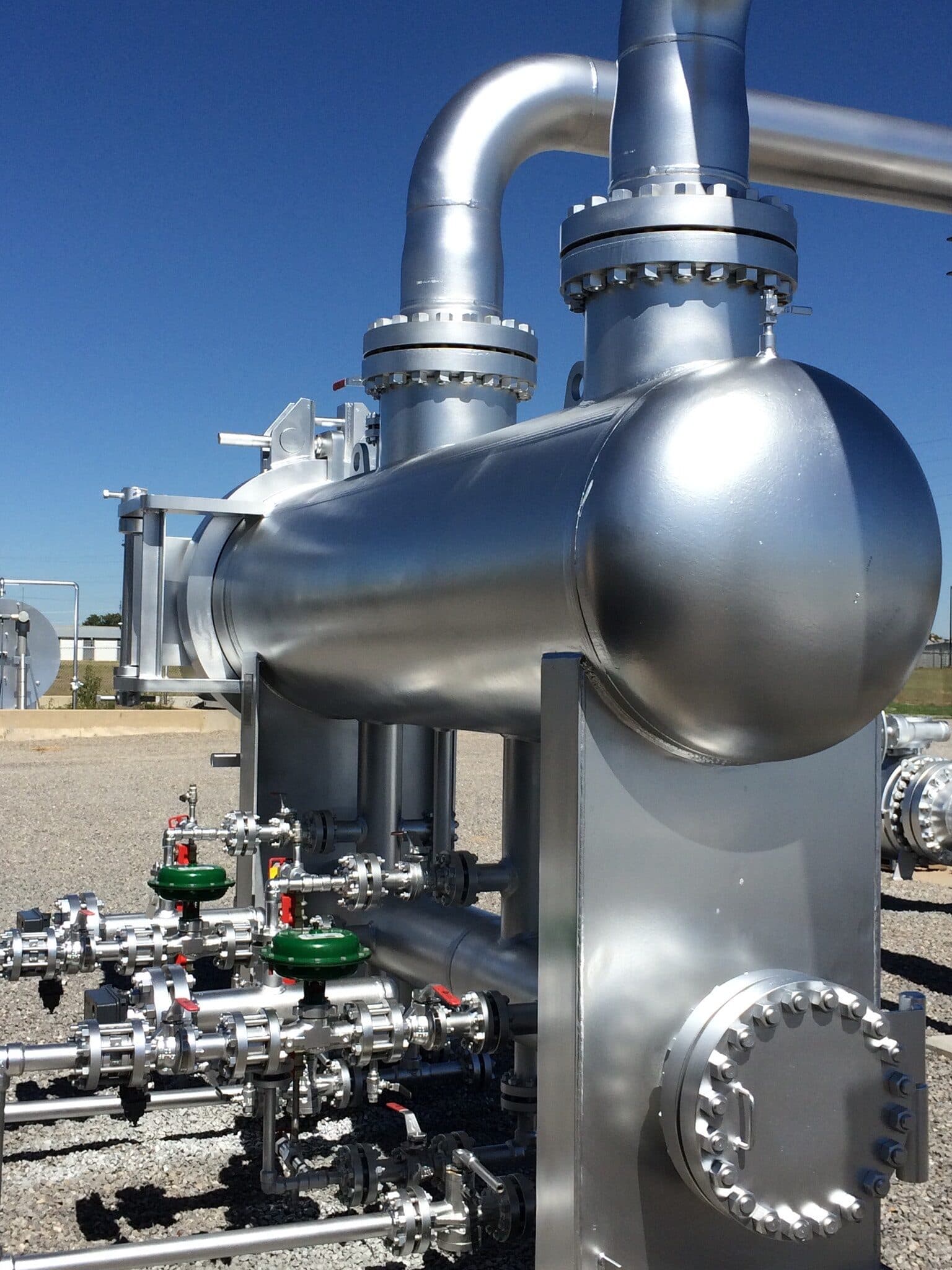 A polished stainless steel separator vessel and valve manifold at a gas facility